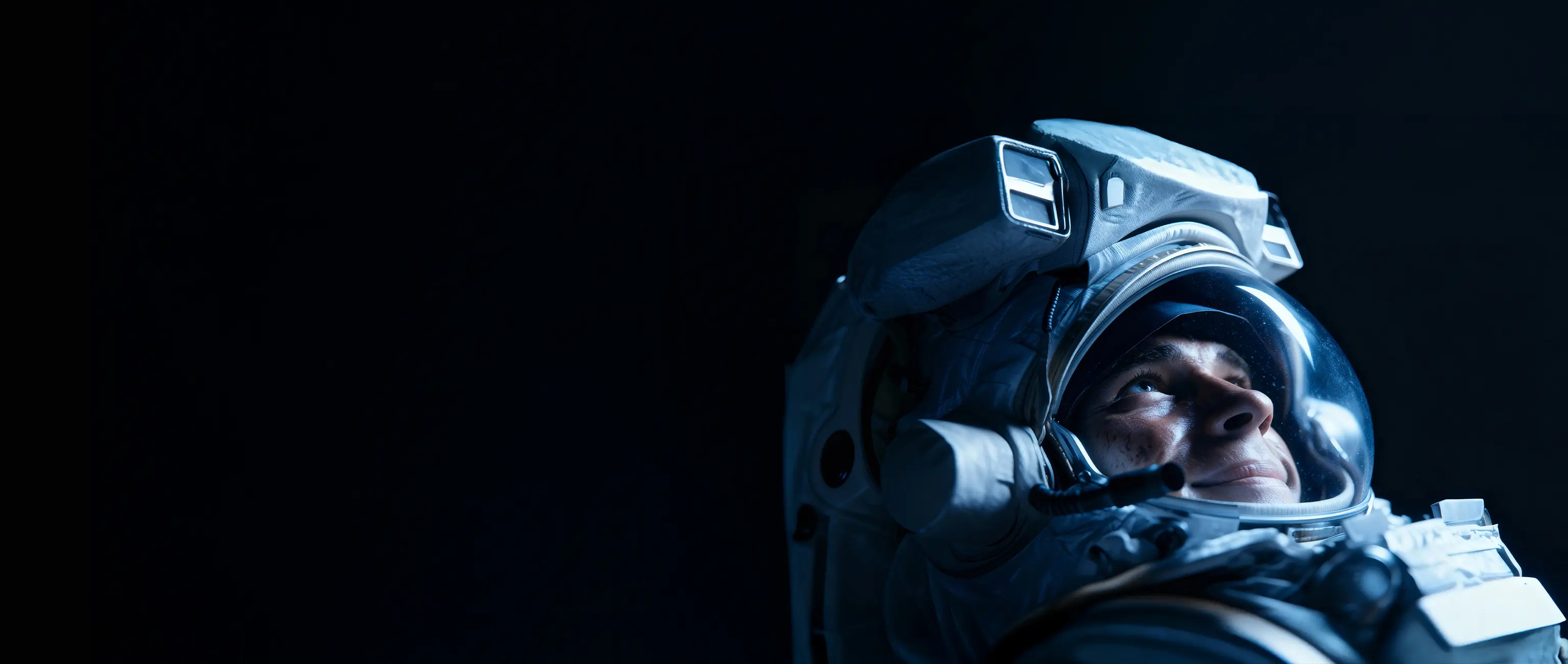 A smiling astronaut in a spacesuit looking up with passion, representing the achievement of high educational and career ambitions with the "My Education" savings plan from National Bonds.