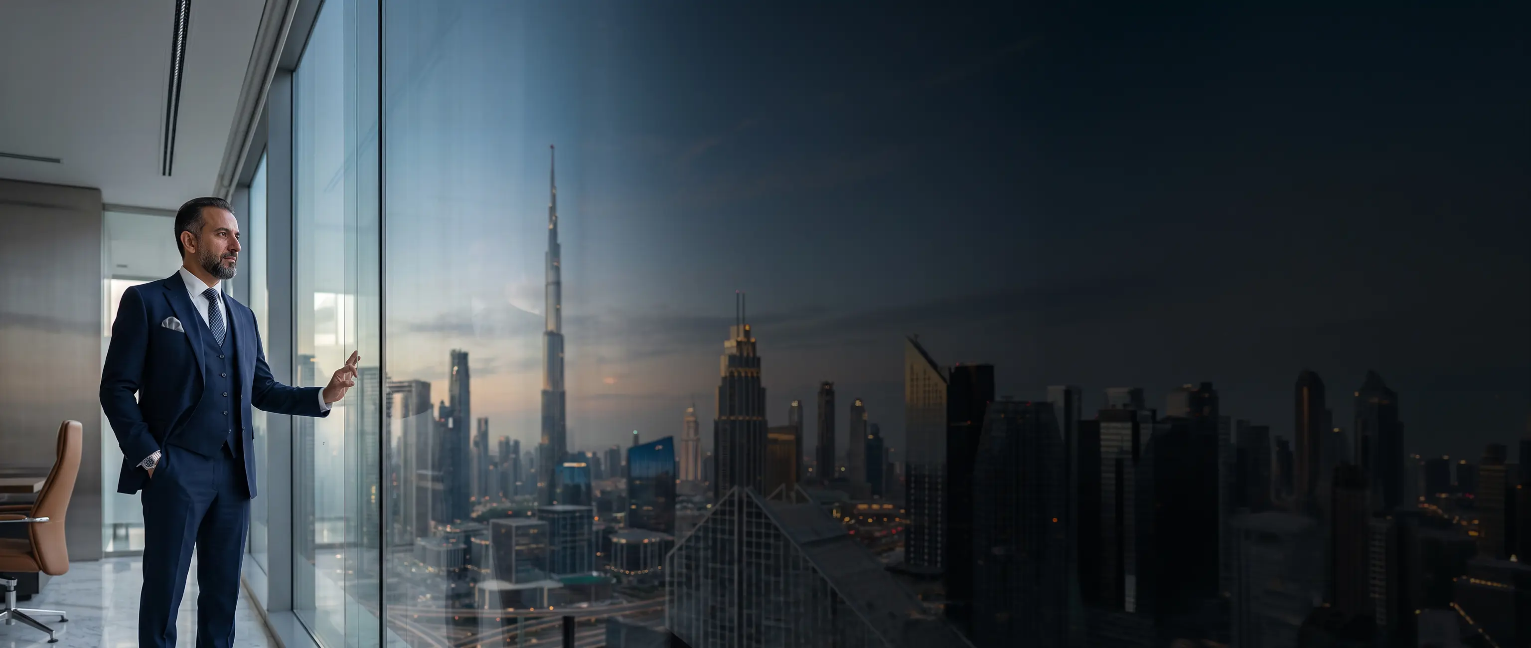 قائد أعمال محترف ينظر بتأمل إلى أفق مدينة دبي من مكتب حديث وشاهق، مما يمثل الرؤية المالية الاستراتيجية وحلول الخزينة المتميزة للشركات من الصكوك الوطنية.