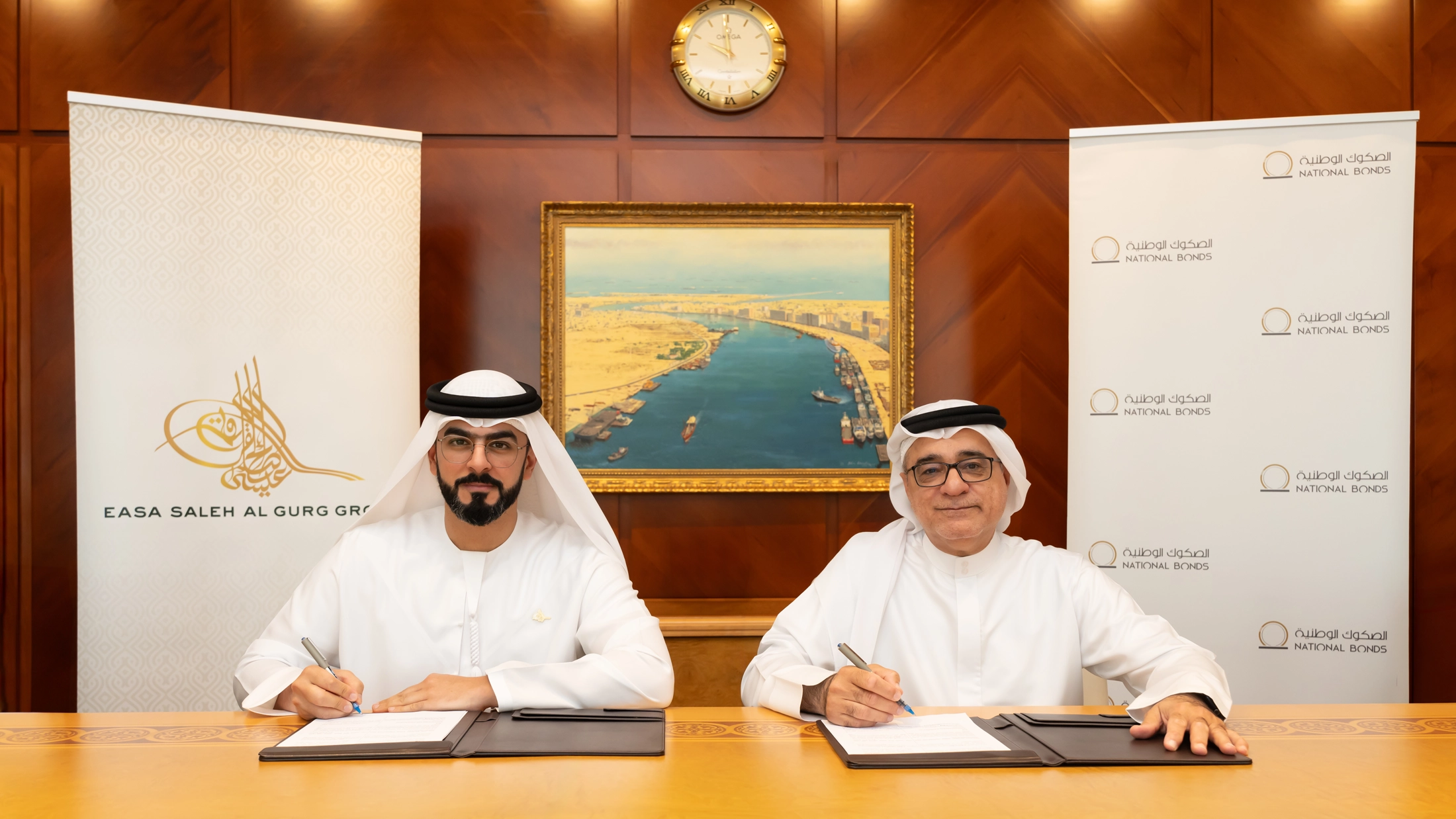 Easa Al Gurg, Group CEO of ESAG, and Mohammed Qasim Al Ali, Group CEO of National Bonds, signing a strategic partnership agreement to foster employee financial security.
